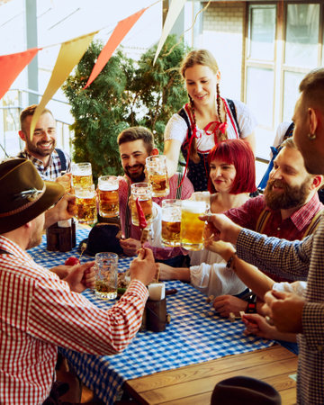 Traditional celebration of beer festival. Group of cheerful people, men and women at bar, drinking beer and having funの写真素材