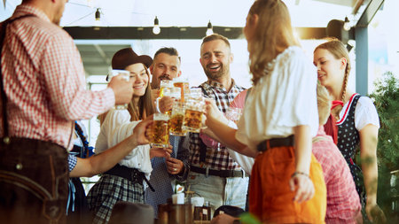 Traditional celebration of beer festival. Group of cheerful people, men and women at bar, drinking beer and having funの写真素材
