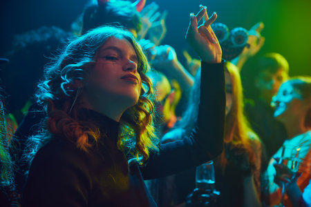 Group of young friends, dressed in spooky and fun costumes, attending nightclub for cheerful celebration of Halloweenの写真素材