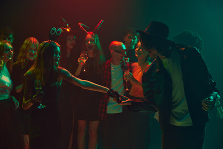 Invitation for a dance. Halloween party scene with young people dressed as ghosts, witches, and...