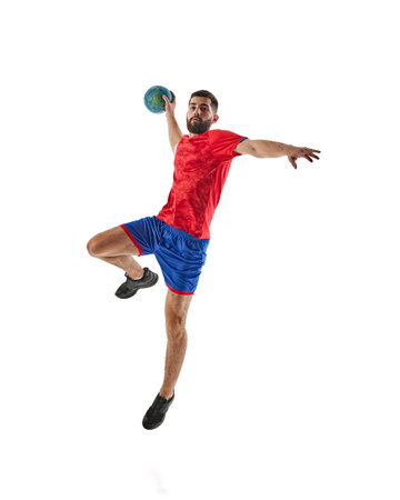 Full-length image of young bearded man, handball player in red and blue uniform in motion with ball isolated on white backgroundの写真素材