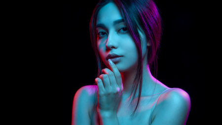 Creative and artistic shot of woman in blue and pink neon lighting, focusing on her natural beauty....