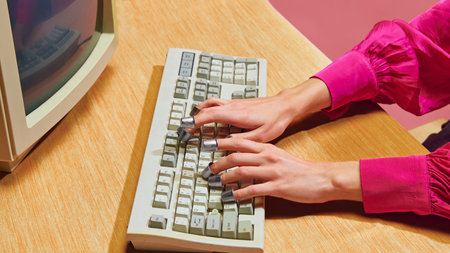Close-up of hands wearing thimbles, typing on keyboard. Quirky and creative approach to business productivityの写真素材