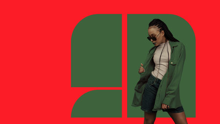 Fashionable young woman wearing green coat and sunglasses posing confidently on bold red and green...
