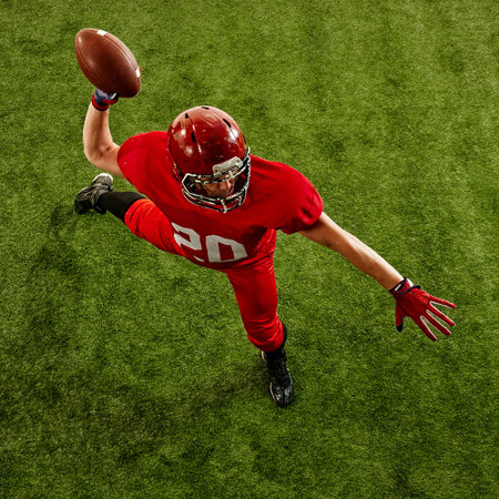 Competitive and determined athlete, American football player in motion on field, competing, throwing...