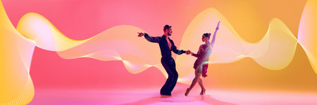 Male and female dancers performing Latin dance in stylish clothes against gradient pink yellow...