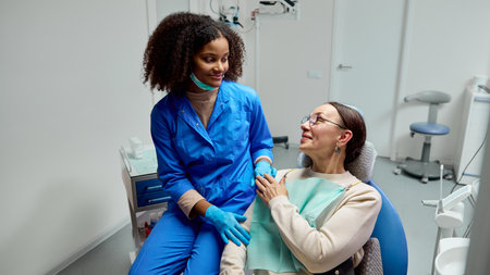 Dentist discusses post-treatment care with patient, explaining how to keep their teeth healthy and...