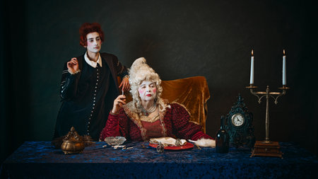Elderly woman, royal person, countess in period attire sitting at table and smoking, young man,...