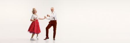 Elderly couple, dressed in vintage-inspired clothing, dances energetically retro dance isolated on white backgroundの写真素材