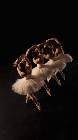 Dynamic moment with ballet dancers, young girls leaping in perfect synchrony on dimly lit stage. Classical baller, grace and artistry.の写真素材