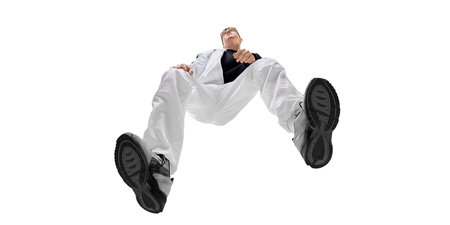 Bottom view image of fashionable young man in white pants and black sneakers, showcasing energy and...