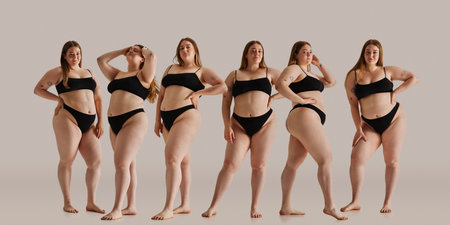 Same model in different poses. Young woman posing proudly in black underwear against neutral background, representing body positivity, and natural beauty.の写真素材
