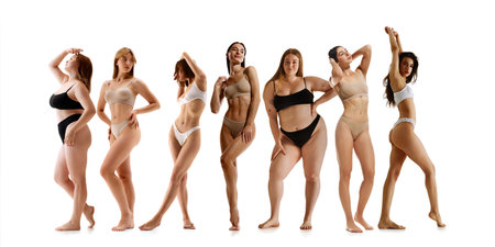 Group of seven women confidently posing in underwear, showcasing body diversity, self-acceptance, and natural beauty against white backgroundの写真素材