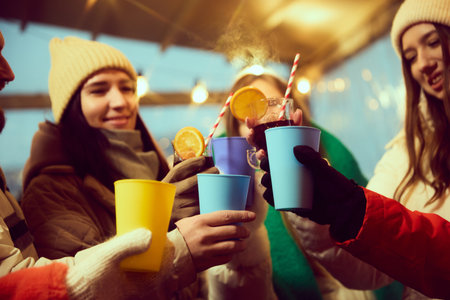 Winter outdoor event. Happy, cheerful young people, friends in warm winter clothes gathering...