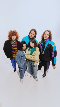 View from above of young men and women in trendy retro outfits, including windbreakers, high-waisted...