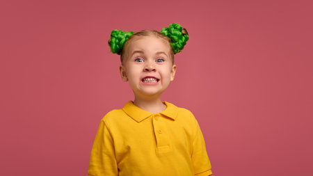 Girl, child in yellow shirt with bright green braided buns, showing excitement, astonishment against...