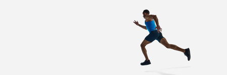Low angle view of muscular man, runner athlete in motion, training isolated on white studio...