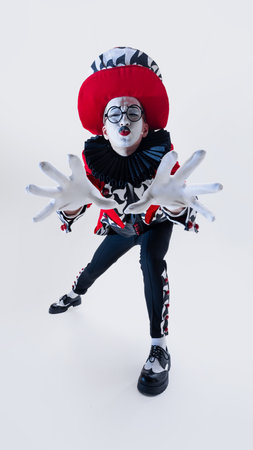 Theatrical mime artist leaning forward with intense gaze and outstretched hands in striking circus...