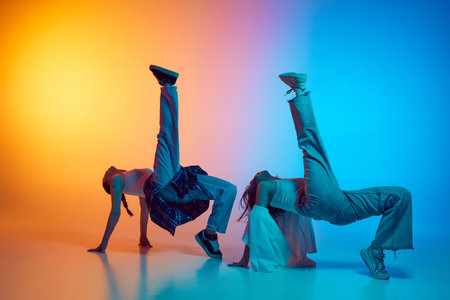 Dynamic image of female dancers moving in sync to hip hop beats against glowing neon gradient background.の写真素材