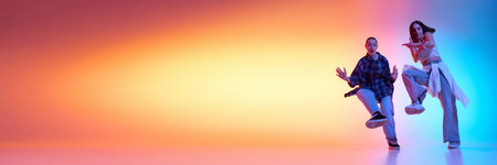 Dynamic image of artistic female hip hop dancers in motion, dancing against gradient studio...