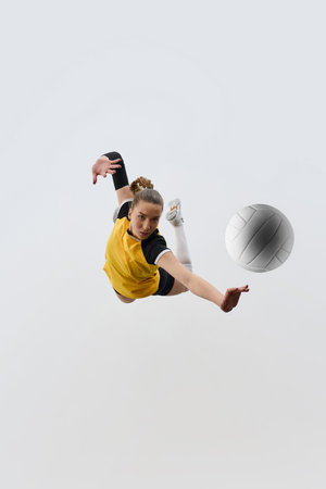Top view dynamic image of female volleyball player in motion during game, hitting ball with precise, training against white background.の写真素材