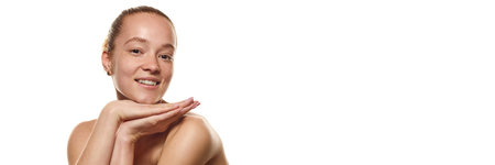 Portrait of young smiling woman with glowing healthy skin posing against white background. C