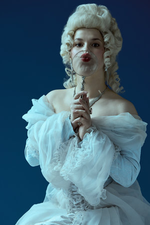 Portrait of young noble lady holding magnifier with lips enlarged, styled as medieval royal.の写真素材