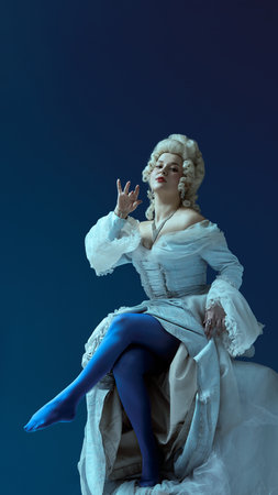 Royal attitude. Female figure in powdered wig and lavish dress raises leg with playful elegance, blending formality with theatrical flairの写真素材