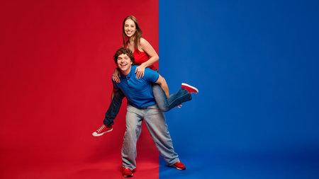 Full-length of young man and woman, couple enjoying piggyback ride, both smiling broadly at the cameraの写真素材