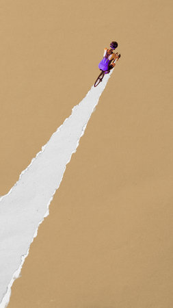 Female cyclist rides upward through torn white path on brown background. Contemporary paper cut style. Concept of sport, game, competition, movement, fitnessの写真素材