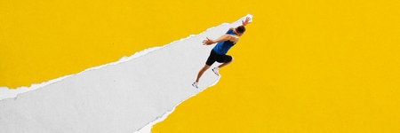 Male runner runs upward on a diagonal torn paper stripe against a yellow background. Textured scrap collage.の写真素材