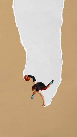 Basketball player jumps high with ball along narrow torn paper stripe on tan background. Paper texture collage.の写真素材
