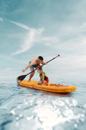 Smiling father paddles with his child daughter sitting on orange sup board over calm water under clear blue sky. Composite image, collageの写真素材