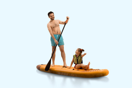 Cheerful father paddles standing on sup board with little girl daughter sitting, smiling and pointing towards isolated in light background.の写真素材