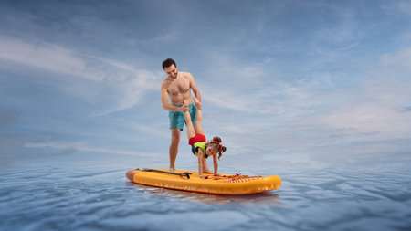 Father helps cheerful daughter perform handstand on sup board on ocean under blue sky. Composite image, collage.の写真素材