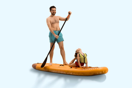 Father smiling, standing on board and paddling while daughter lying in yoga stitching position on board against light background.の写真素材