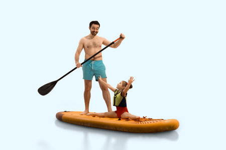 Happy father paddles on paddleboard and looking at his happy daughter performs split on orange sup board in swimsuit.の写真素材
