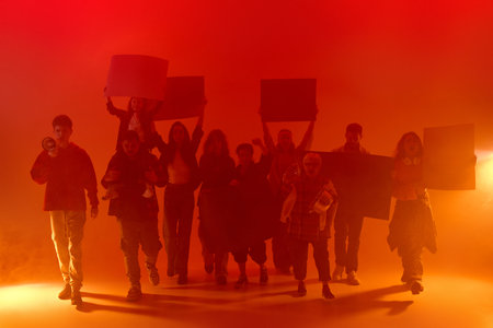 March of demonstrators, people diverse nationality and ages, in red neon light with posters and...