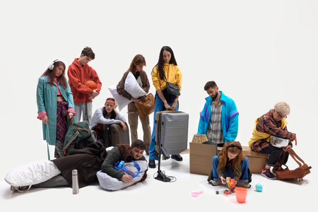 People collapse on floor surrounded by personal belongings after long journey or displacement. Concept of evacuation, refugee experience, social issuesの写真素材