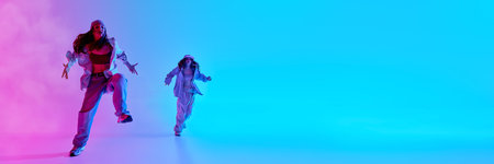 Flexible, talented teenage girls dancing together in colorful studio with smoke effects and dramatic...