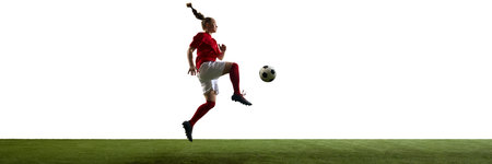 Young footballer leaping to strike ball mid-motion with intensity and skill on arena against white background with negative space. Banner.の写真素材