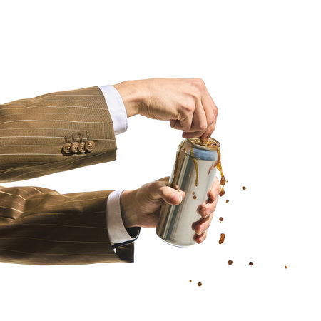 Bold beverage. Male hands in business suit forcefully opening soda can with coffee splashing out.の写真素材