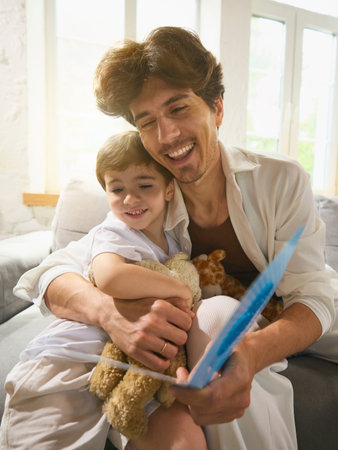 Father hugging his young son after receiving a handmade Fathers Day cardの写真素材