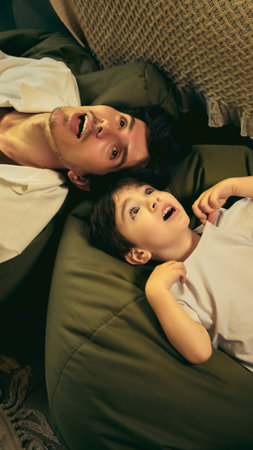 Relaxed love. Father and son enjoying playful bonding time on bean bag laughingの写真素材