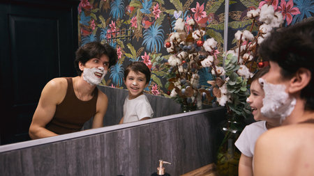 Father and son enjoy bonding moment while shaving together in colorful bathroom settingの写真素材