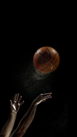Basketball shot in mid-air with players arms extendedの写真素材