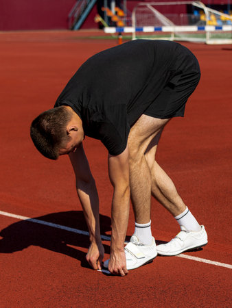 Athlete preparing with stretches on track beneath sunny sky before run