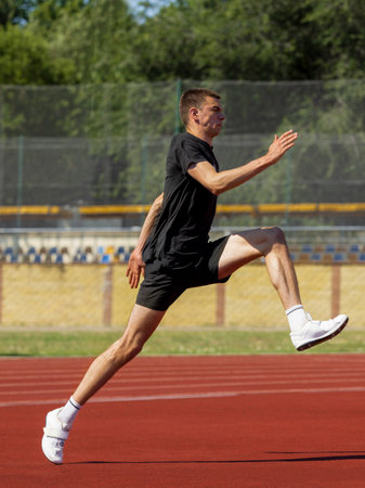 Athlete sprinting while airborne during training on red track