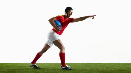 Rugby athlete advancing on grass pitch with outstretched armの写真素材