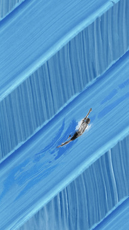 Surreal collage of male swimmer gliding forward on stylized blue brushstroke water